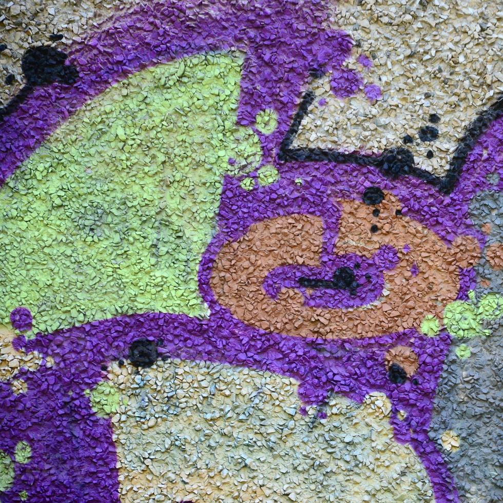 fragmento de dibujos de graffiti. la antigua muralla decorada con manchas de pintura al estilo de la cultura del arte callejero. textura de fondo coloreada en tonos cálidos foto