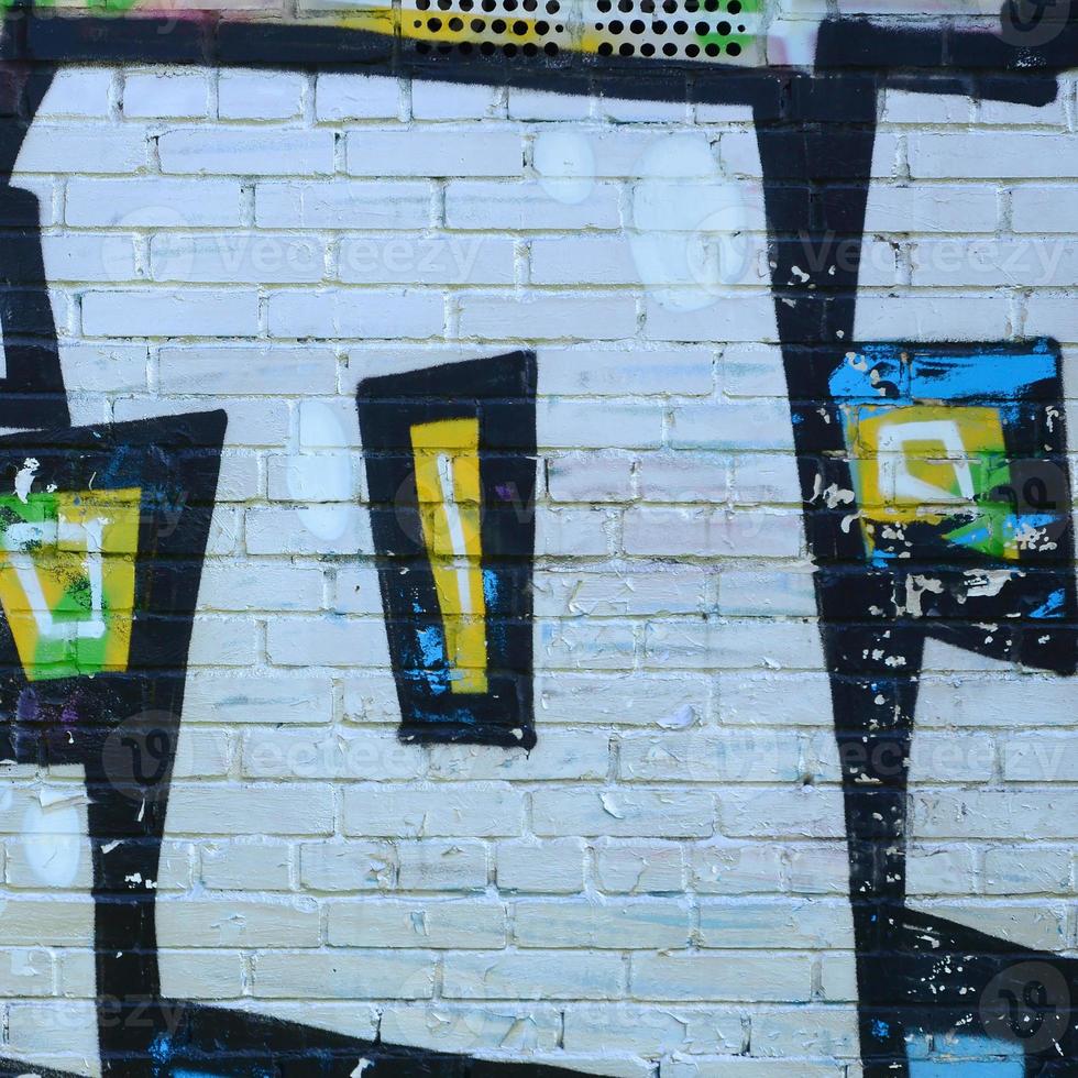 Fragment of graffiti drawings. The old wall decorated with paint stains in the style of street art culture. Colored background texture photo