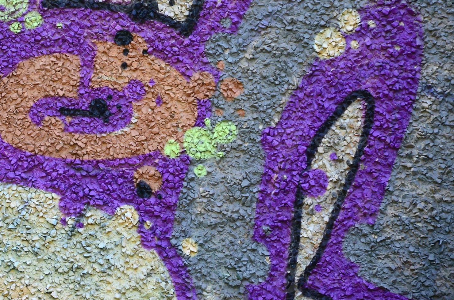 Fragment of graffiti drawings. The old wall decorated with paint stains in the style of street art culture. Colored background texture in warm tones photo