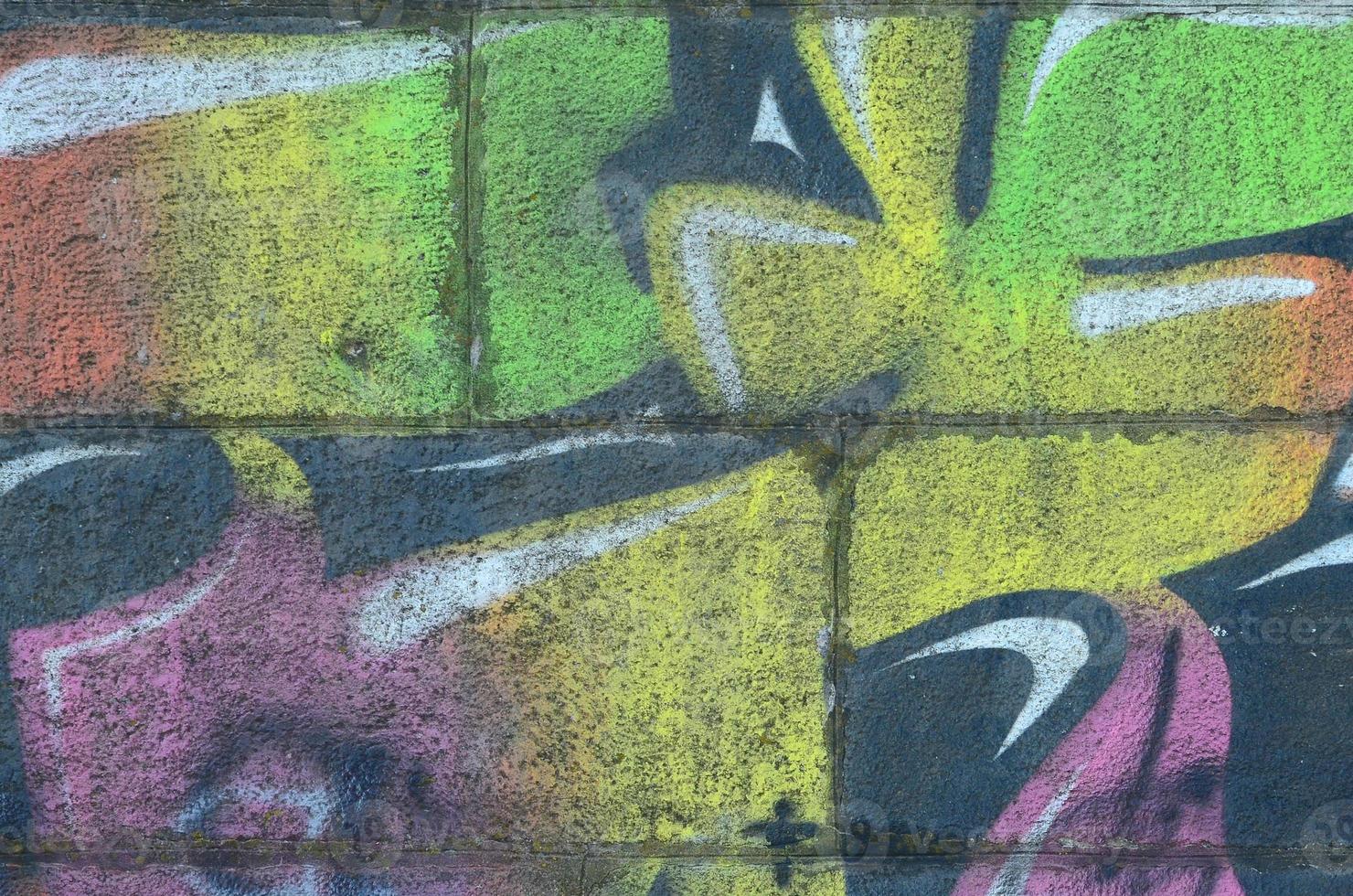 fragmento de dibujos de graffiti. la antigua muralla decorada con manchas de pintura al estilo de la cultura del arte callejero. textura de fondo multicolor foto