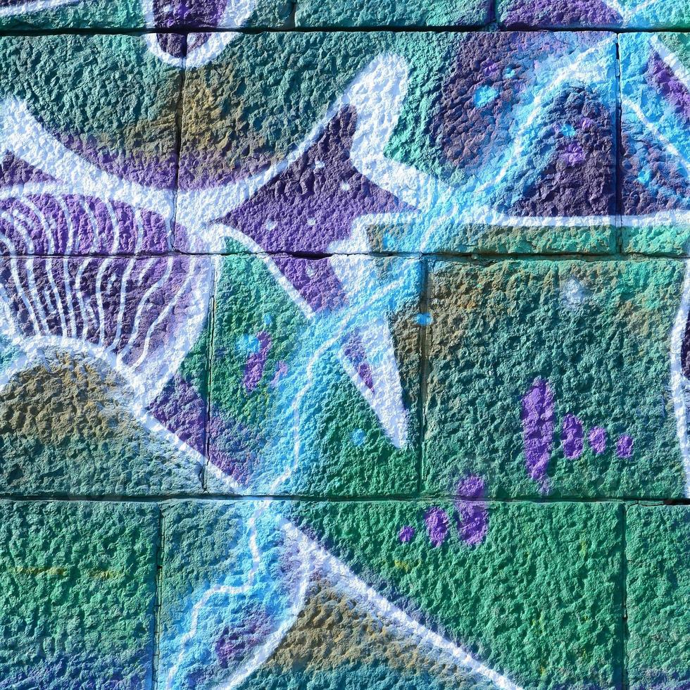 Fragment of graffiti drawings. The old wall decorated with paint stains in the style of street art culture. Colored background texture in cold tones photo