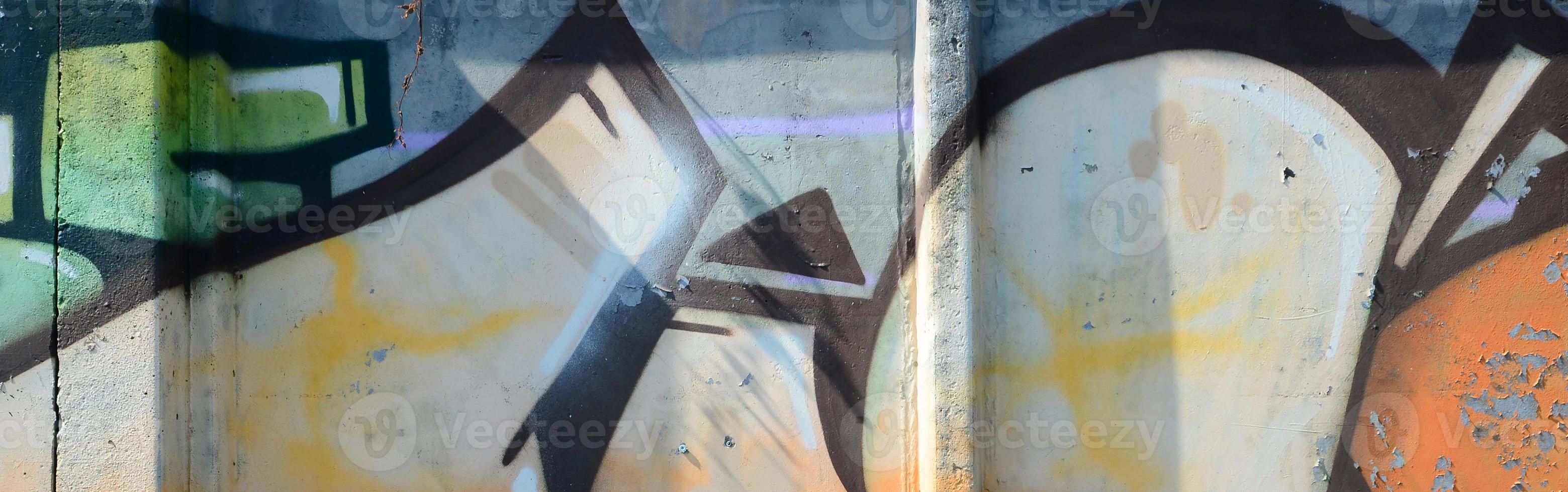Fragment of graffiti drawings. The old wall decorated with paint stains in the style of street art culture. Colored background texture in warm tones photo