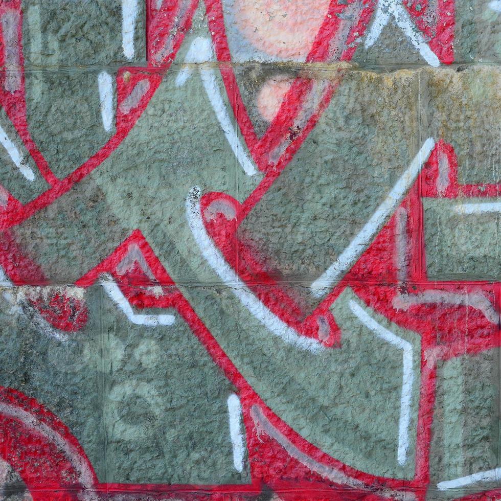 fragmento de dibujos de graffiti. la antigua muralla decorada con manchas de pintura al estilo de la cultura del arte callejero. textura de fondo coloreada en tonos cálidos foto