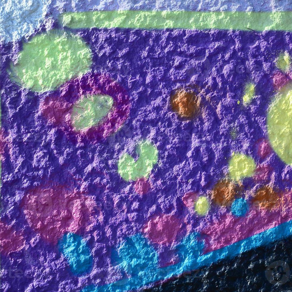 Fragment of graffiti drawings. The old wall decorated with paint stains in the style of street art culture. Multicolored background texture photo