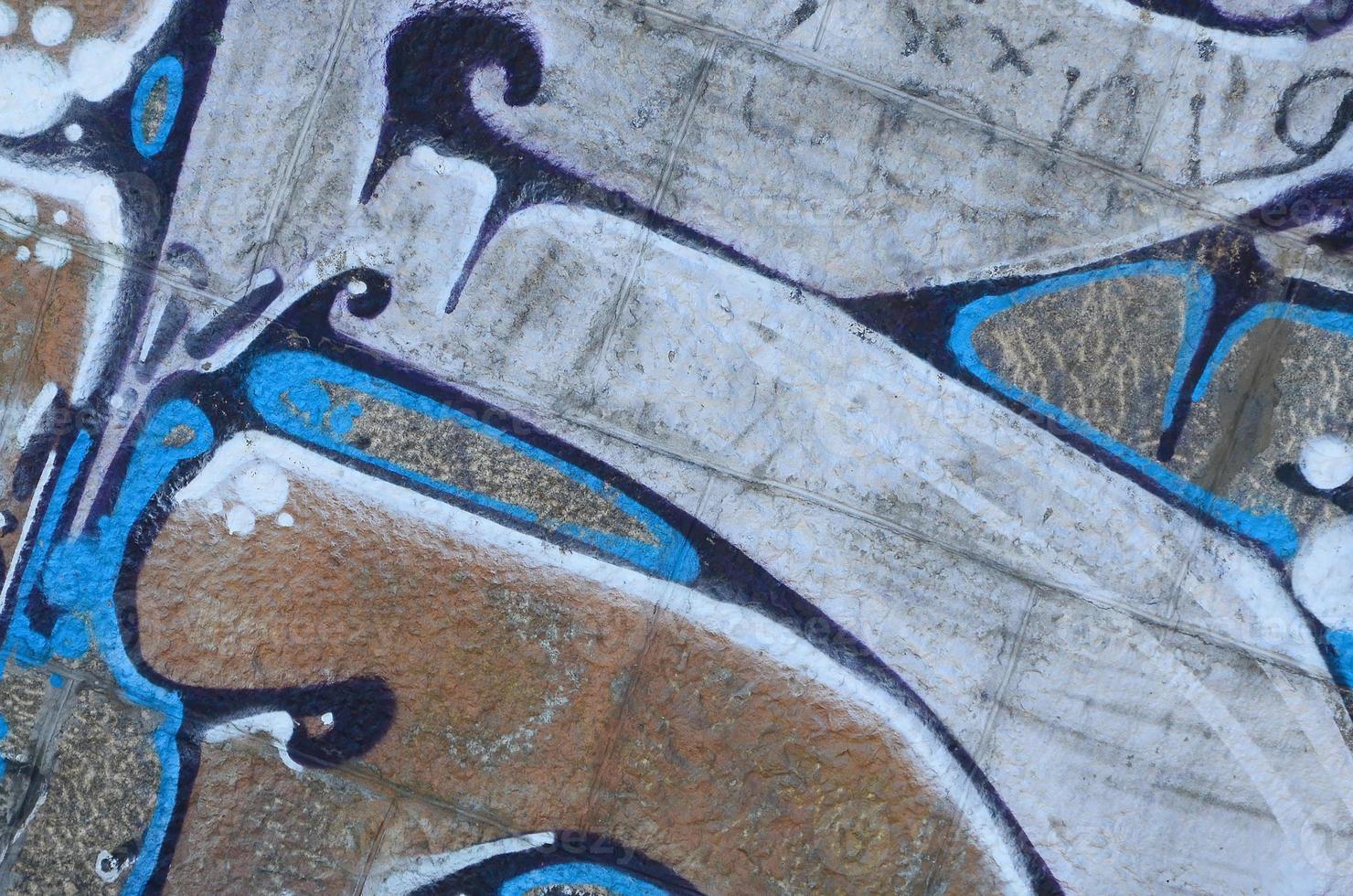 Fragment of graffiti drawings. The old wall decorated with paint stains in the style of street art culture. Colored background texture in warm tones photo