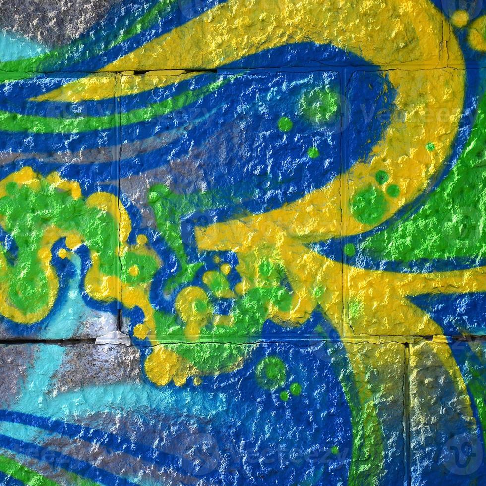 Fragment of graffiti drawings. The old wall decorated with paint stains in the style of street art culture. Colored background texture in green tones photo