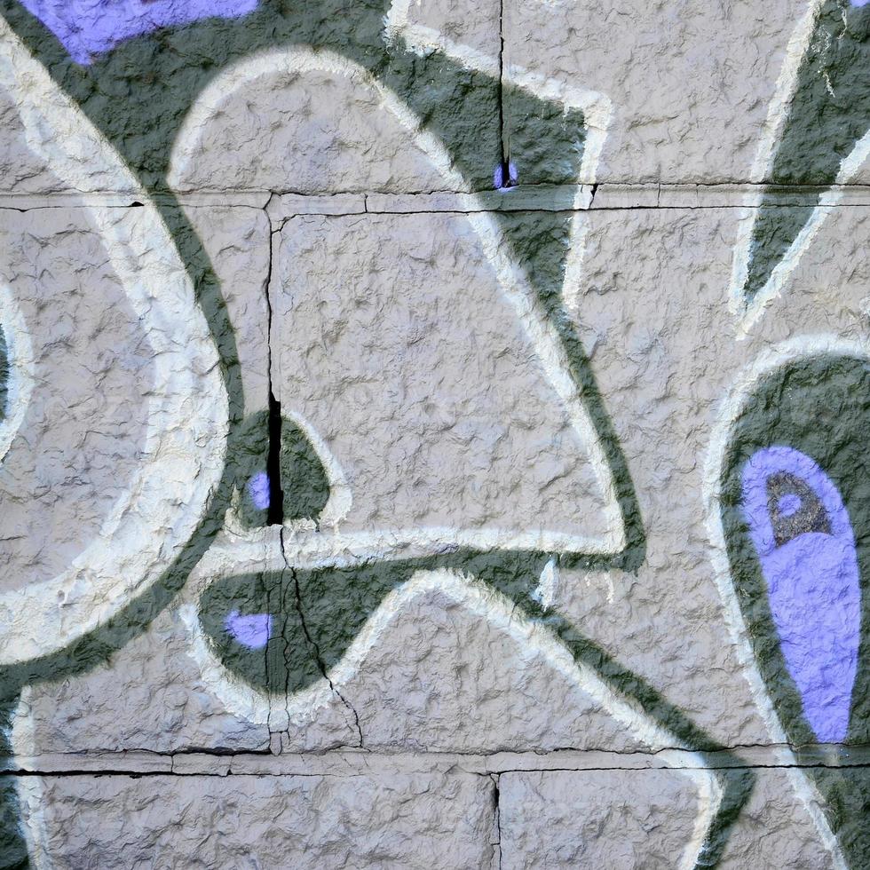 fragmento de dibujos de graffiti. la antigua muralla decorada con manchas de pintura al estilo de la cultura del arte callejero. textura de fondo coloreada en tonos morados foto