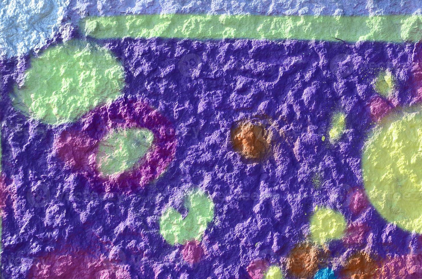 Fragment of graffiti drawings. The old wall decorated with paint stains in the style of street art culture. Multicolored background texture photo