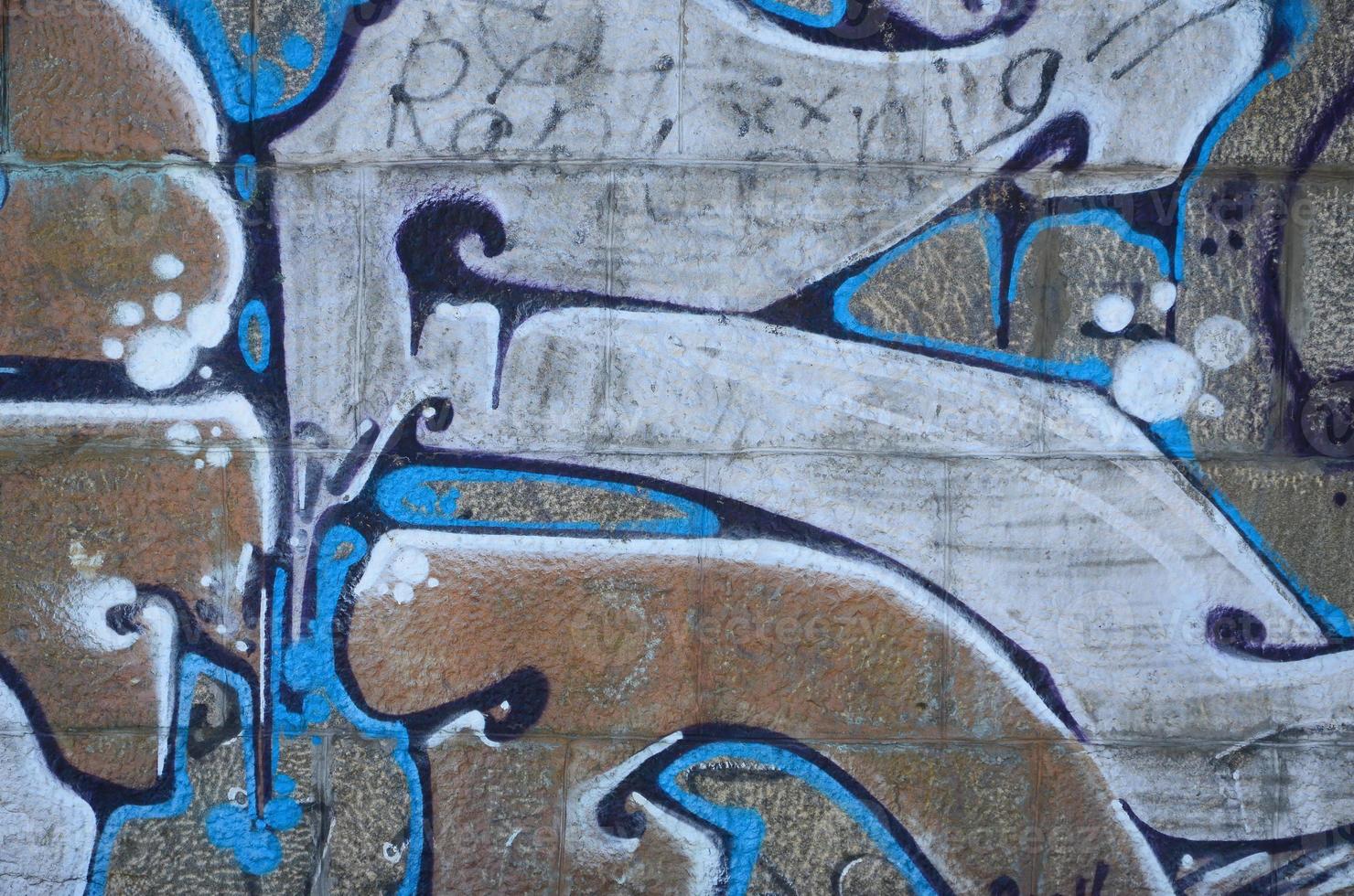 Fragment of graffiti drawings. The old wall decorated with paint stains in the style of street art culture. Colored background texture in warm tones photo