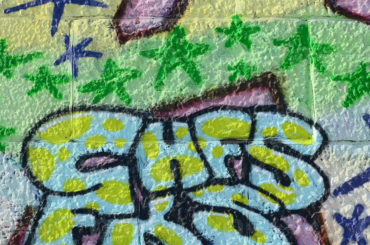 fragmento de dibujos de graffiti. la antigua muralla decorada con manchas de pintura al estilo de la cultura del arte callejero. textura de fondo coloreada en tonos verdes foto