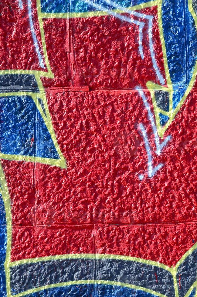 fragmento de dibujos de graffiti. la antigua muralla decorada con manchas de pintura al estilo de la cultura del arte callejero. textura de fondo coloreada en tonos cálidos foto