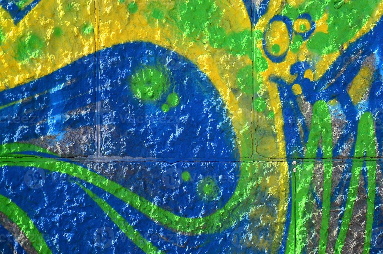 Fragment of graffiti drawings. The old wall decorated with paint stains in the style of street art culture. Colored background texture in green tones photo