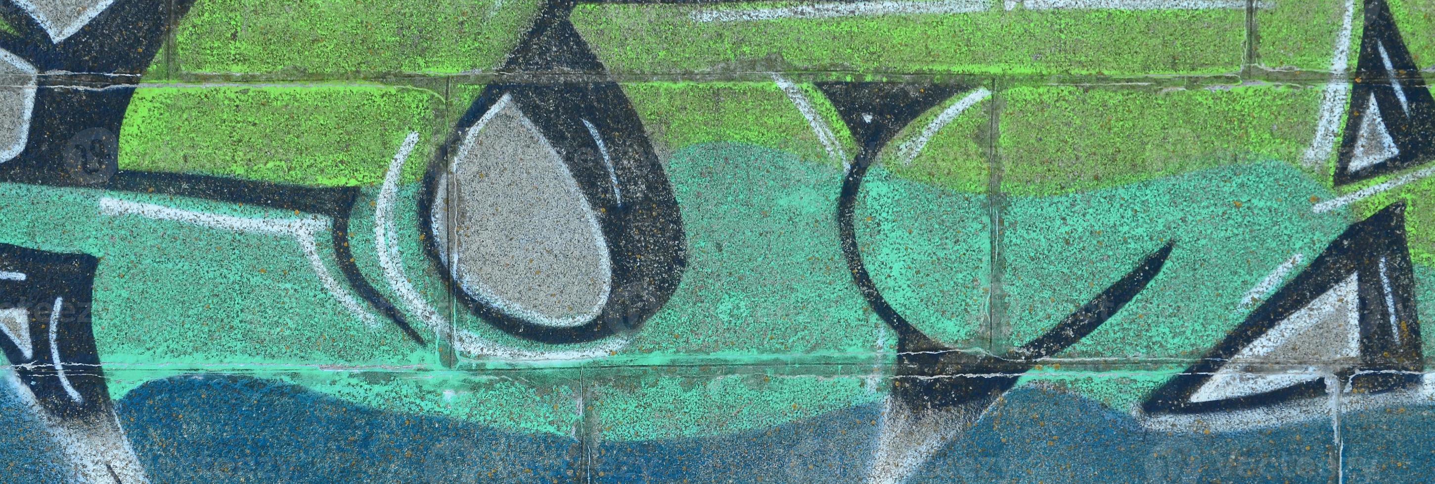 Fragment of graffiti drawings. The old wall decorated with paint stains in the style of street art culture. Colored background texture in green tones photo