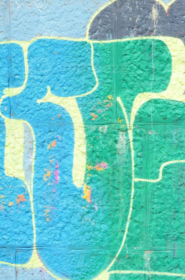 Fragment of graffiti drawings. The old wall decorated with paint stains in the style of street art culture. Colored background texture in green tones photo