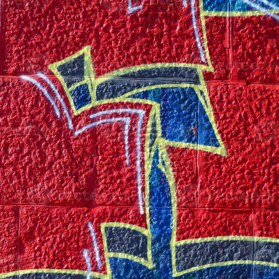 Fragment of graffiti drawings. The old wall decorated with paint stains in the style of street art culture. Colored background texture in warm tones photo