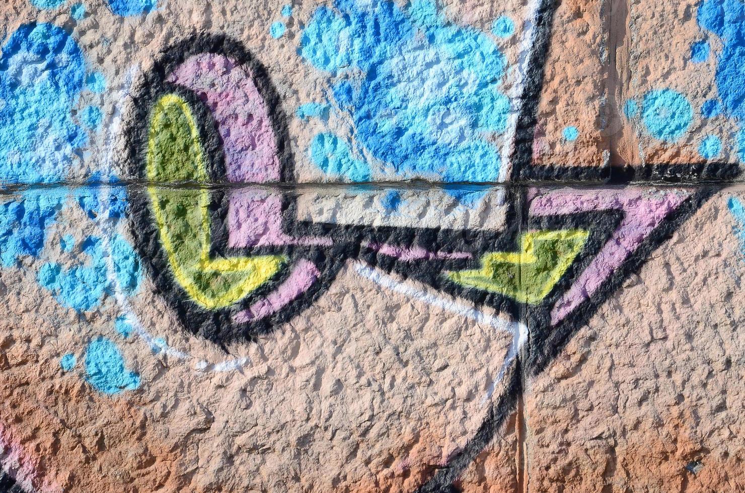Fragment of graffiti drawings. The old wall decorated with paint stains in the style of street art culture. Colored background texture in warm tones photo