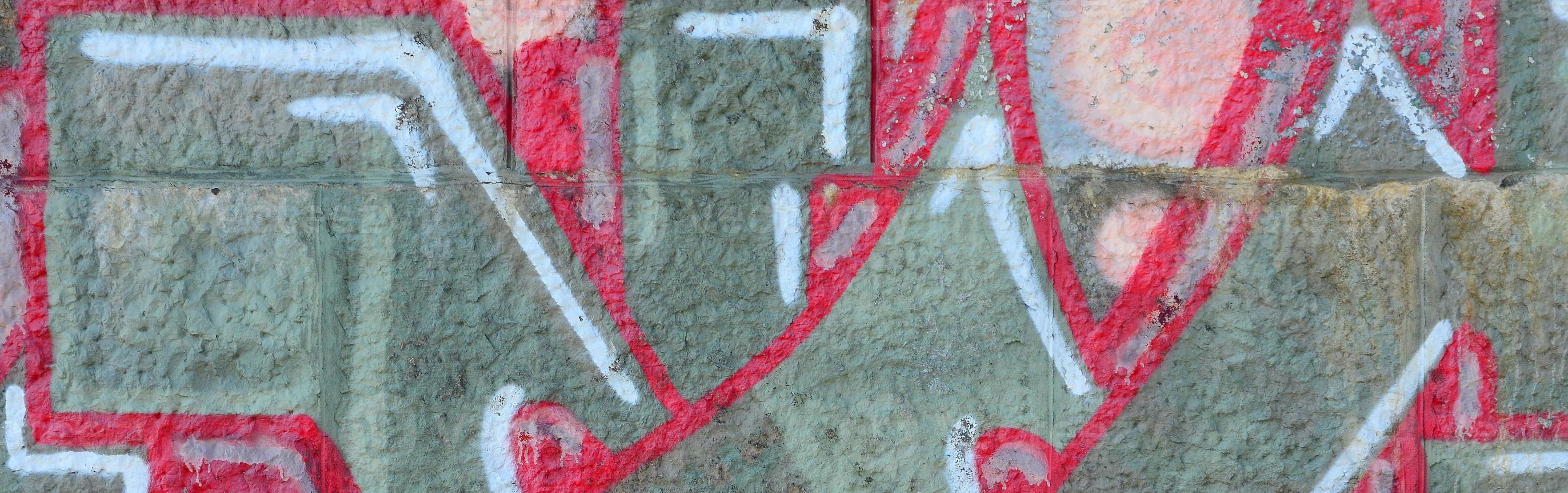 Fragment of graffiti drawings. The old wall decorated with paint stains in the style of street art culture. Colored background texture in warm tones photo