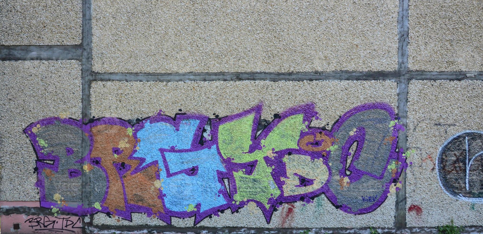 fragmento de dibujos de graffiti. la antigua muralla decorada con manchas de pintura al estilo de la cultura del arte callejero. textura de fondo coloreada en tonos fríos foto