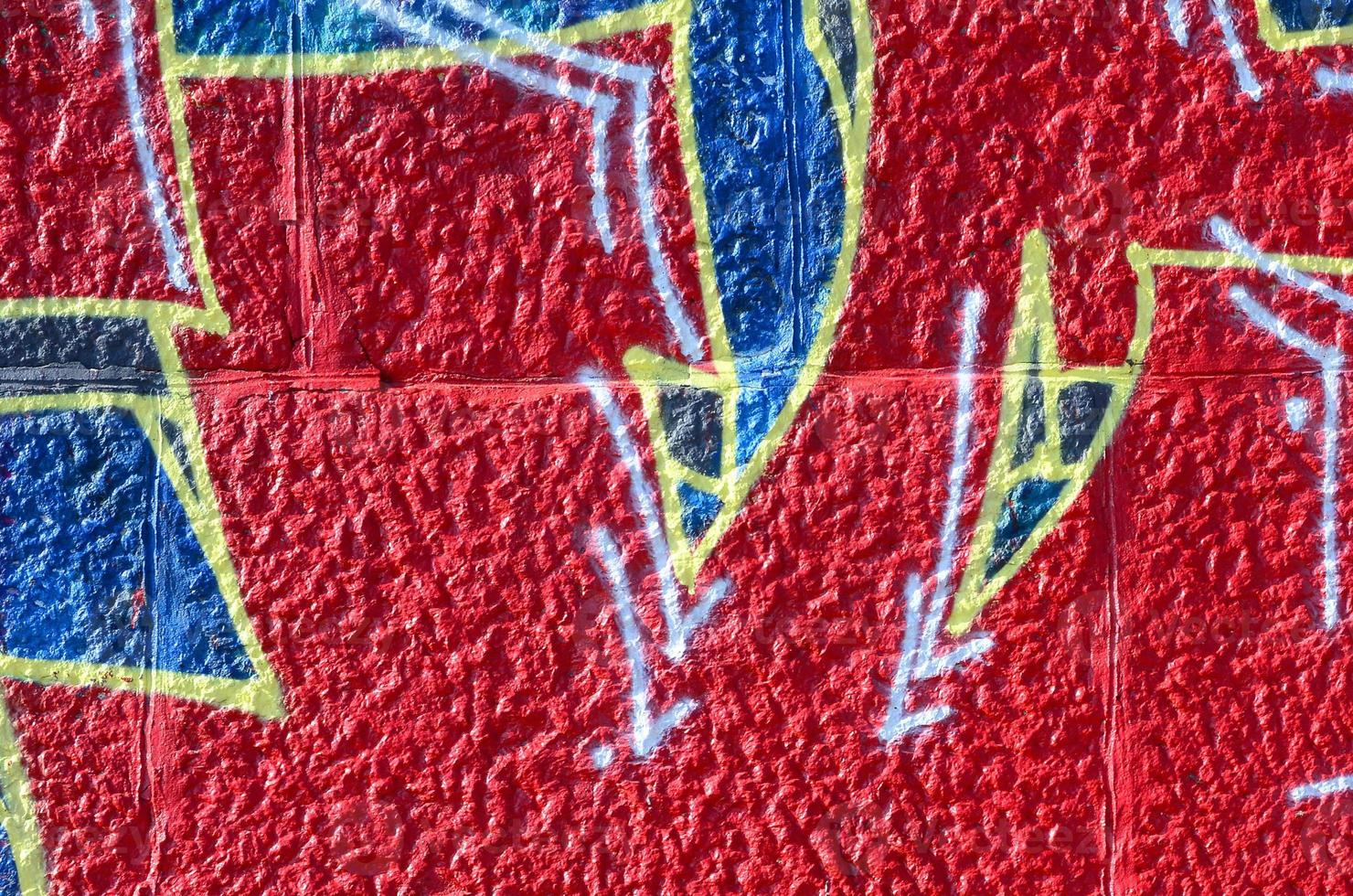 Fragment of graffiti drawings. The old wall decorated with paint stains in the style of street art culture. Colored background texture in warm tones photo