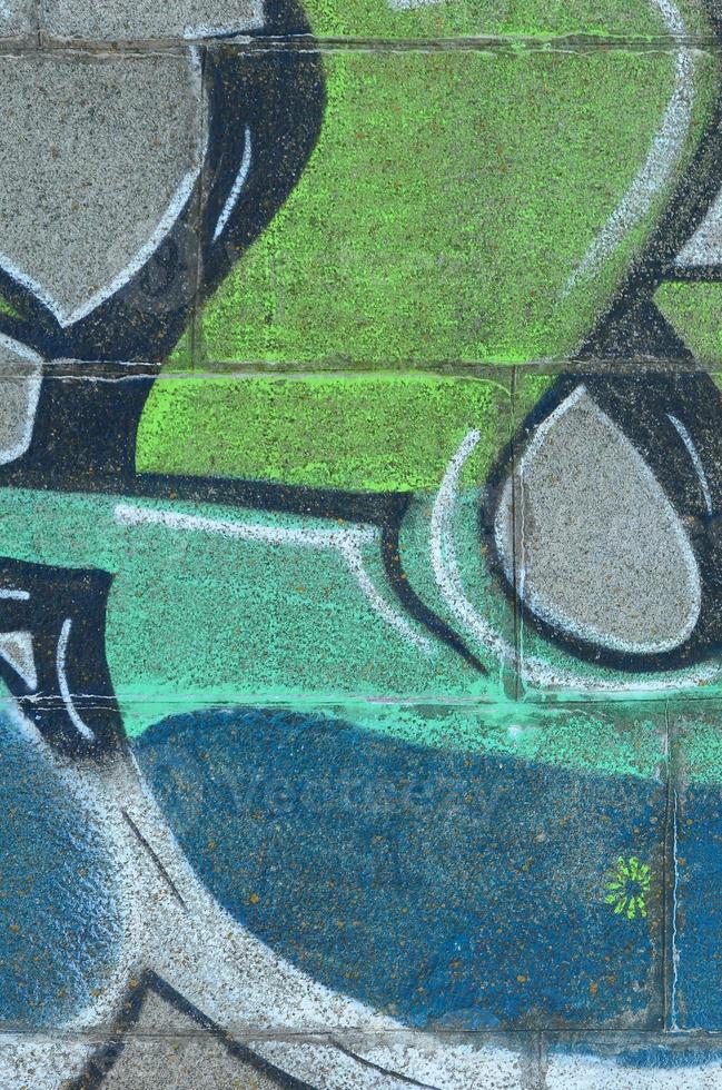 Fragment of graffiti drawings. The old wall decorated with paint stains in the style of street art culture. Colored background texture in green tones photo