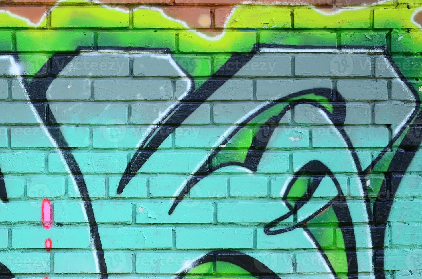 Fragment of graffiti drawings. The old wall decorated with paint stains in the style of street art culture. Colored background texture in green tones photo