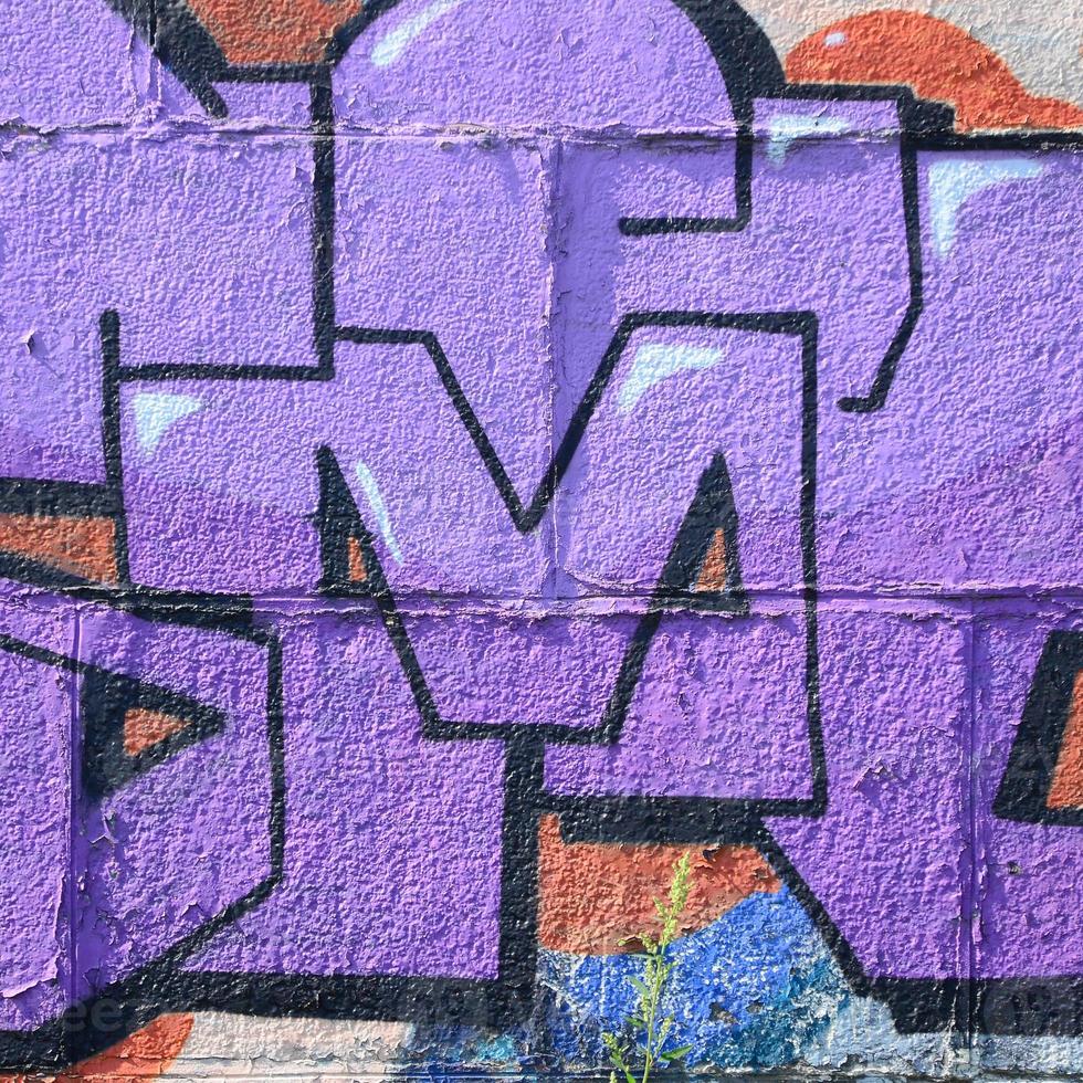 fragmento de dibujos de graffiti. la antigua muralla decorada con manchas de pintura al estilo de la cultura del arte callejero. textura de fondo coloreada en tonos morados foto