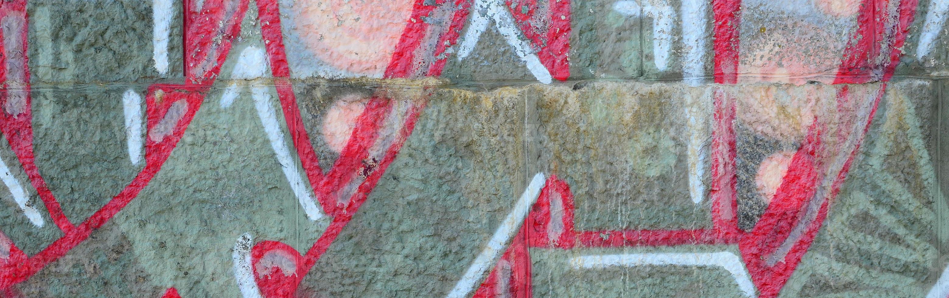 Fragment of graffiti drawings. The old wall decorated with paint stains in the style of street art culture. Colored background texture in warm tones photo