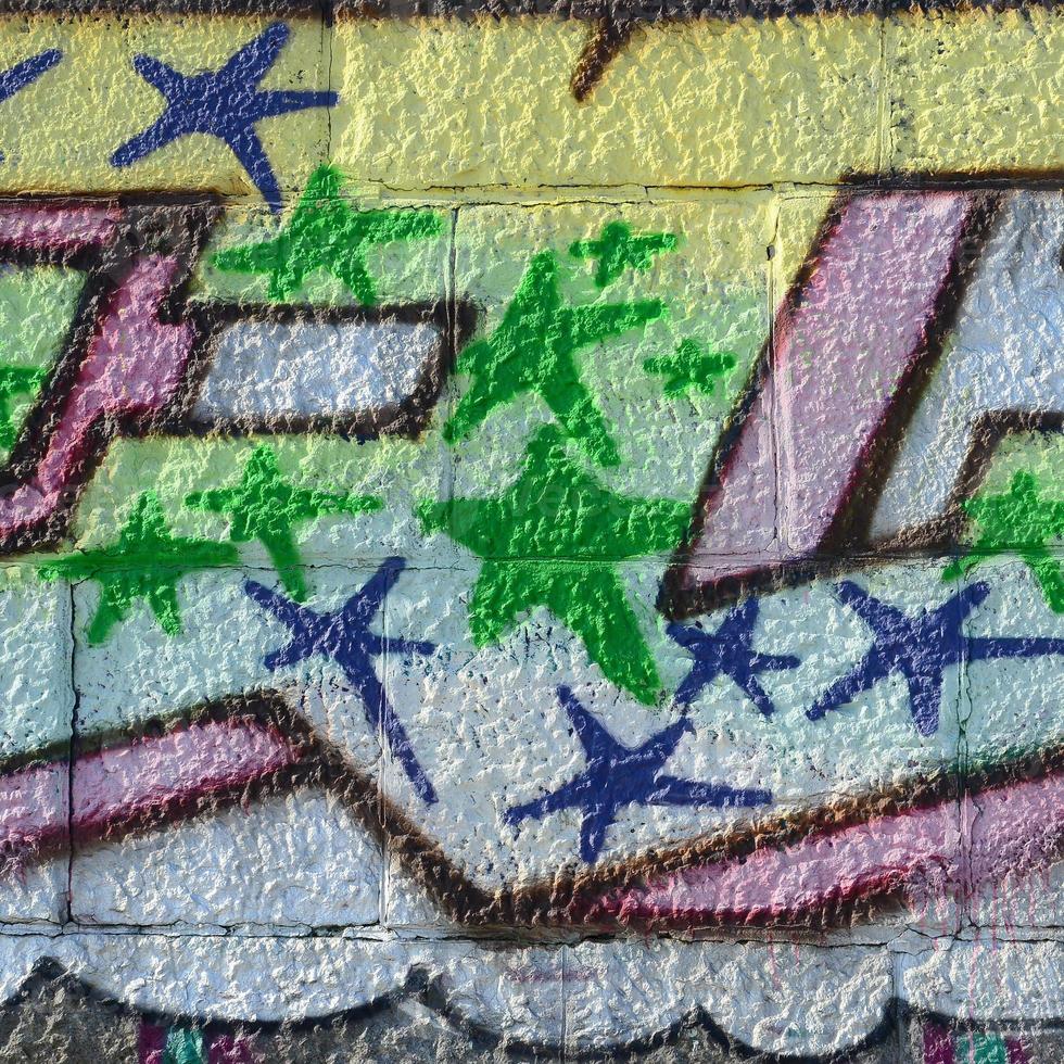 Fragment of graffiti drawings. The old wall decorated with paint stains in the style of street art culture. Colored background texture in green tones photo