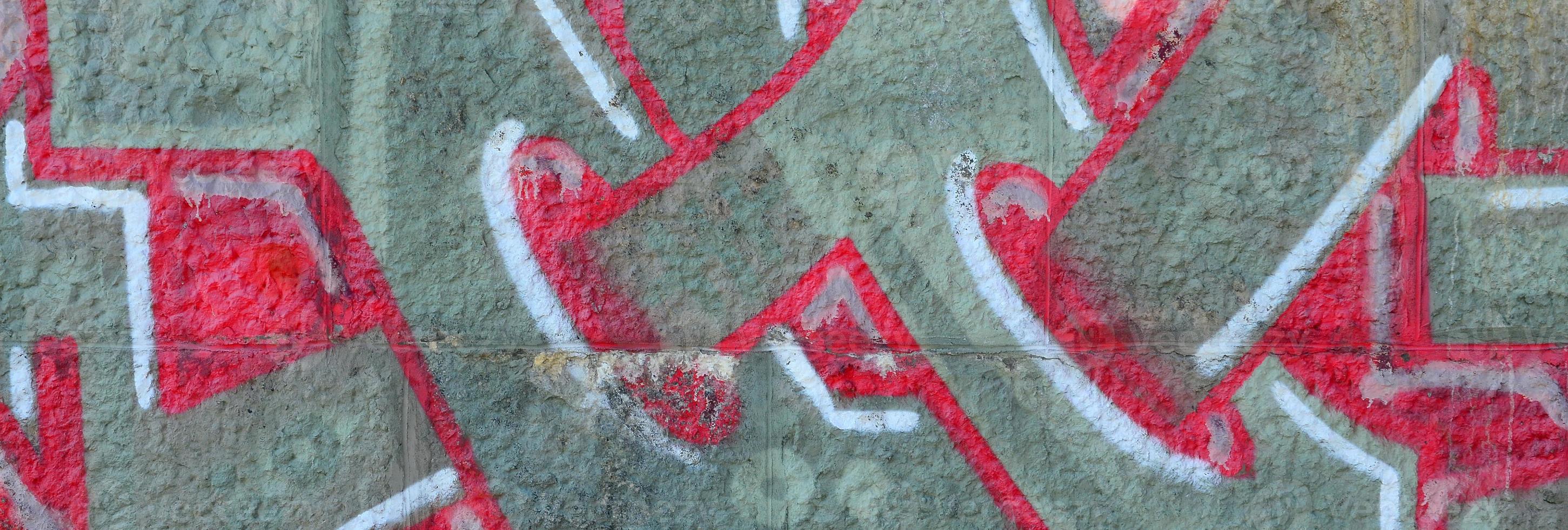 Fragment of graffiti drawings. The old wall decorated with paint stains in the style of street art culture. Colored background texture in warm tones photo