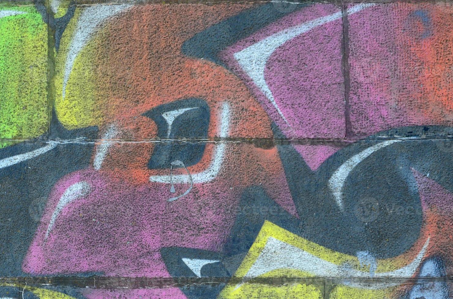 Fragment of graffiti drawings. The old wall decorated with paint stains in the style of street art culture. Multicolored background texture photo