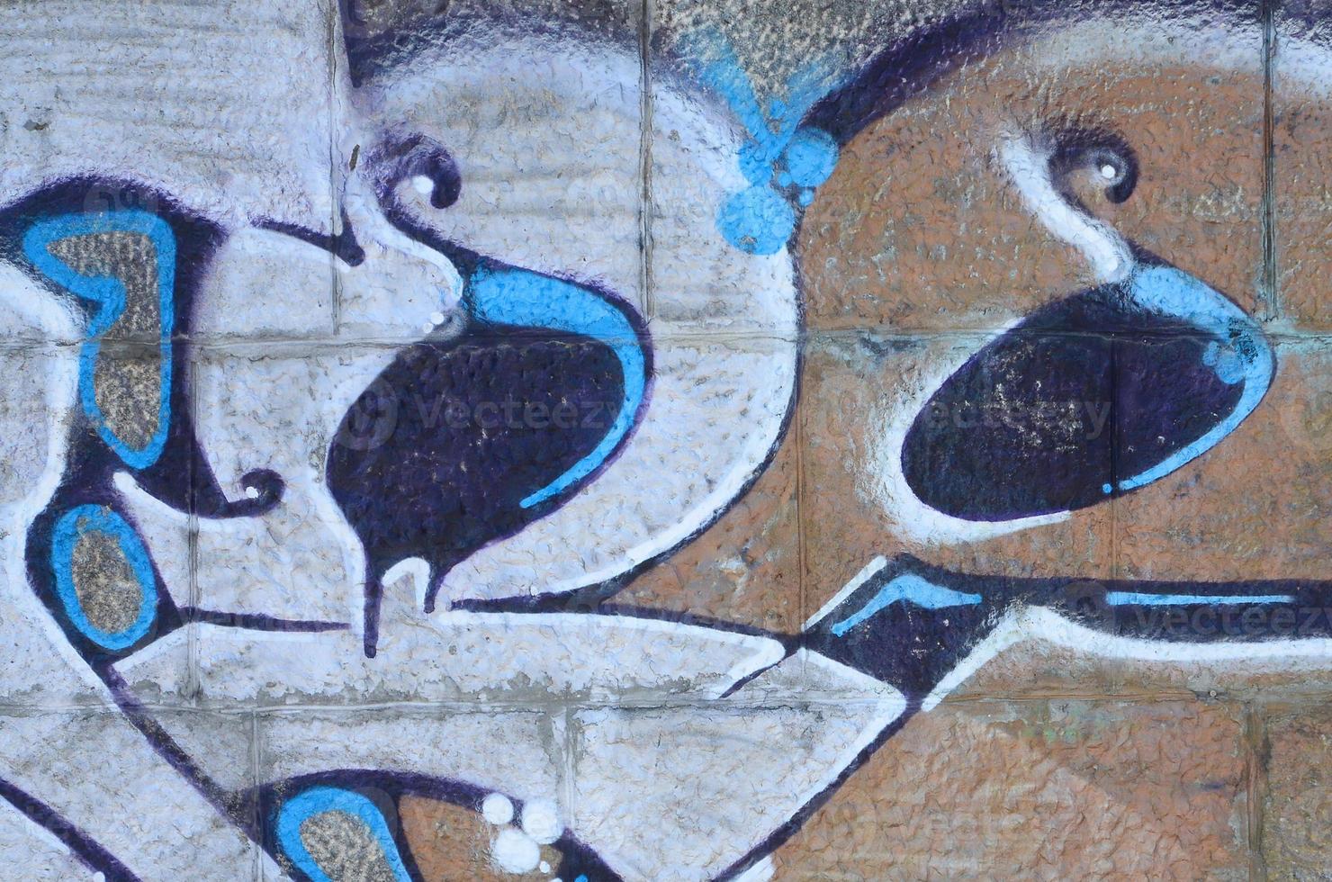 Fragment of graffiti drawings. The old wall decorated with paint stains in the style of street art culture. Colored background texture in warm tones photo