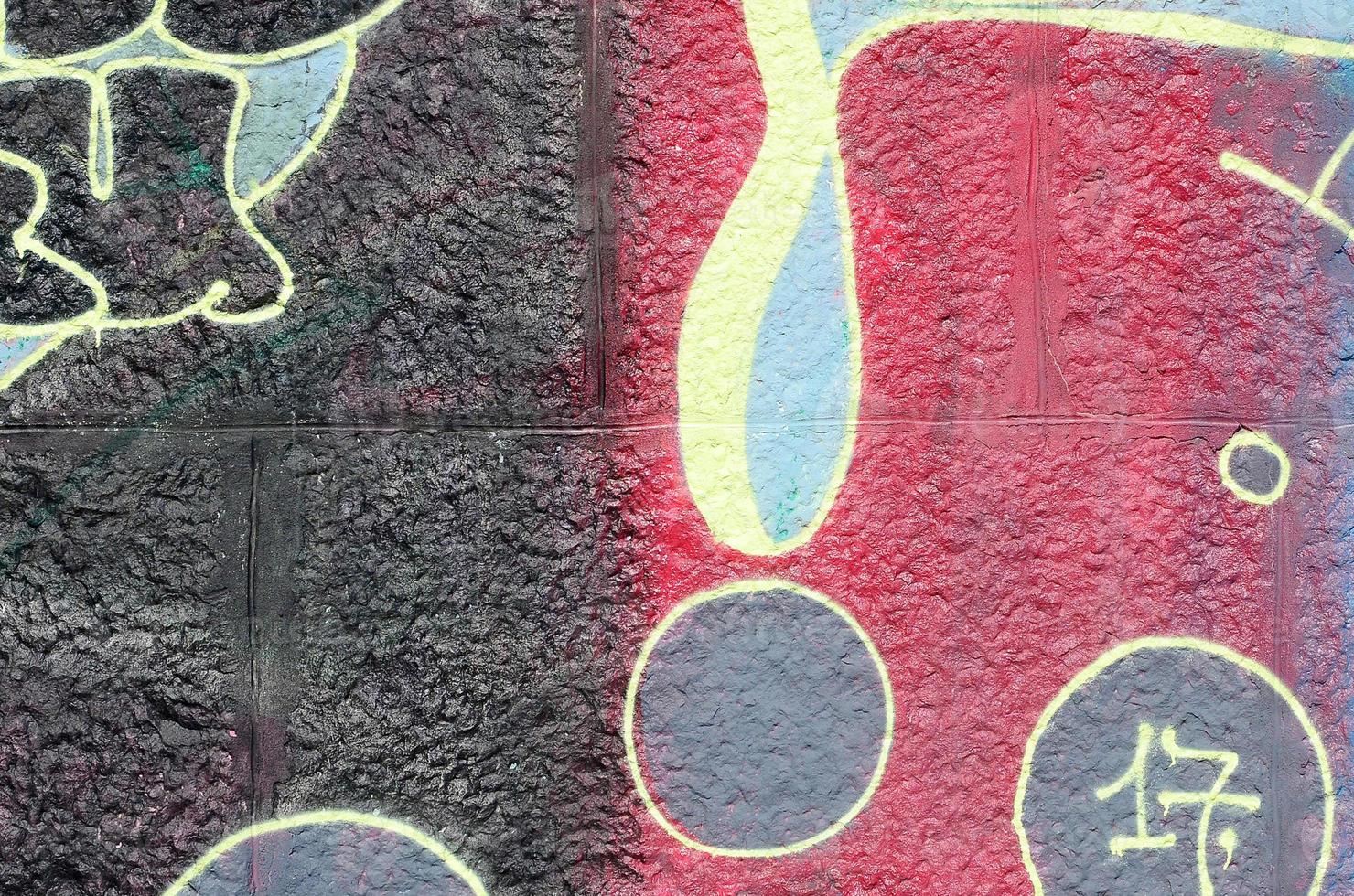 Fragment of graffiti drawings. The old wall decorated with paint stains in the style of street art culture. Multicolored background texture photo