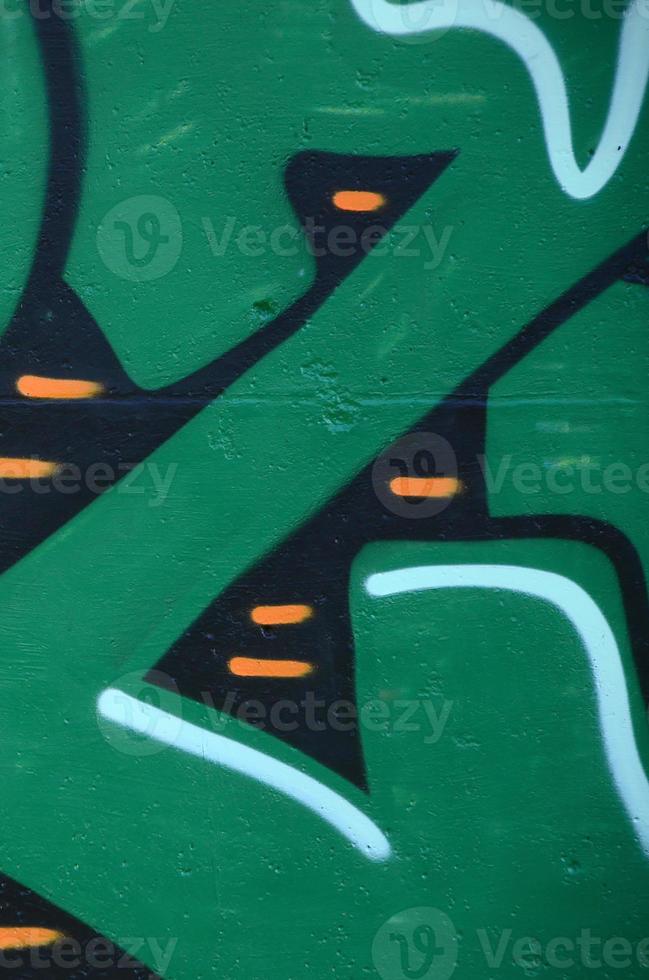 Fragment of graffiti drawings. The old wall decorated with paint stains in the style of street art culture. Colored background texture in green tones photo