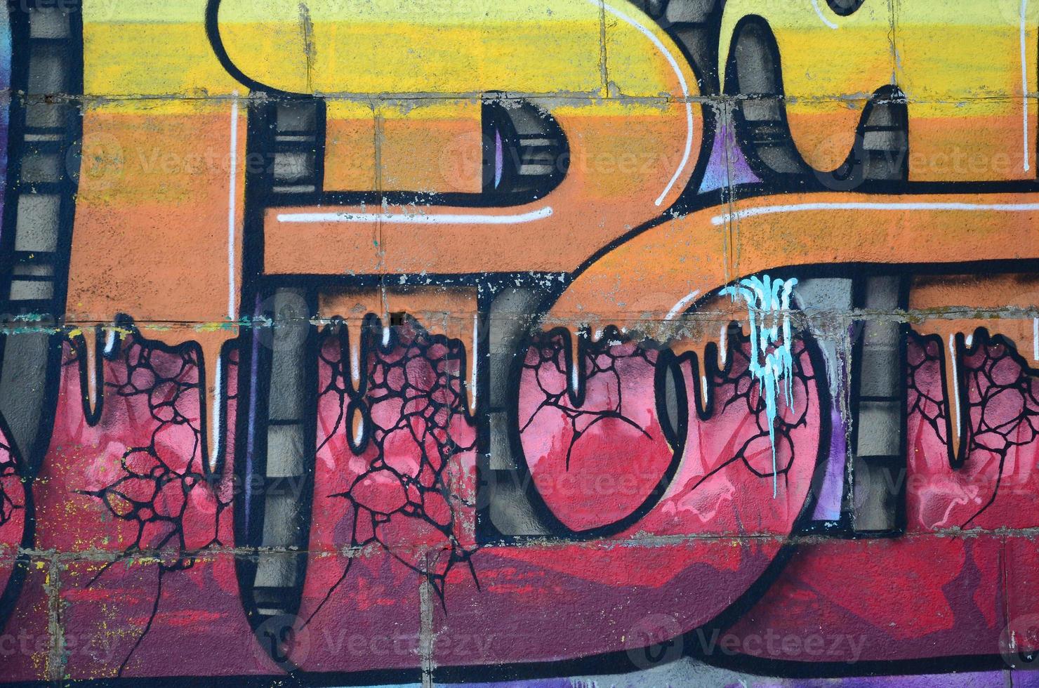 Fragment of graffiti drawings. The old wall decorated with paint stains in the style of street art culture. Colored background texture in warm tones photo