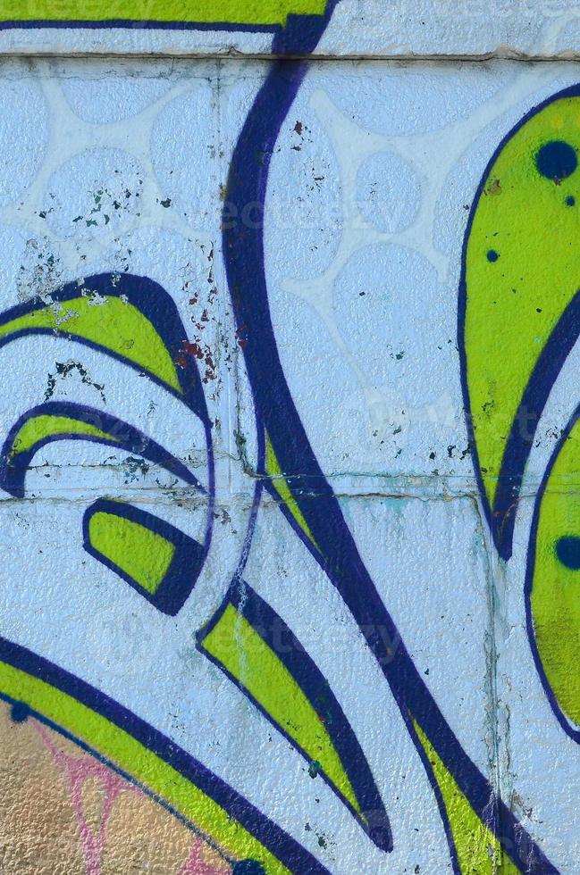 Fragment of graffiti drawings. The old wall decorated with paint stains in the style of street art culture. Colored background texture in green tones photo