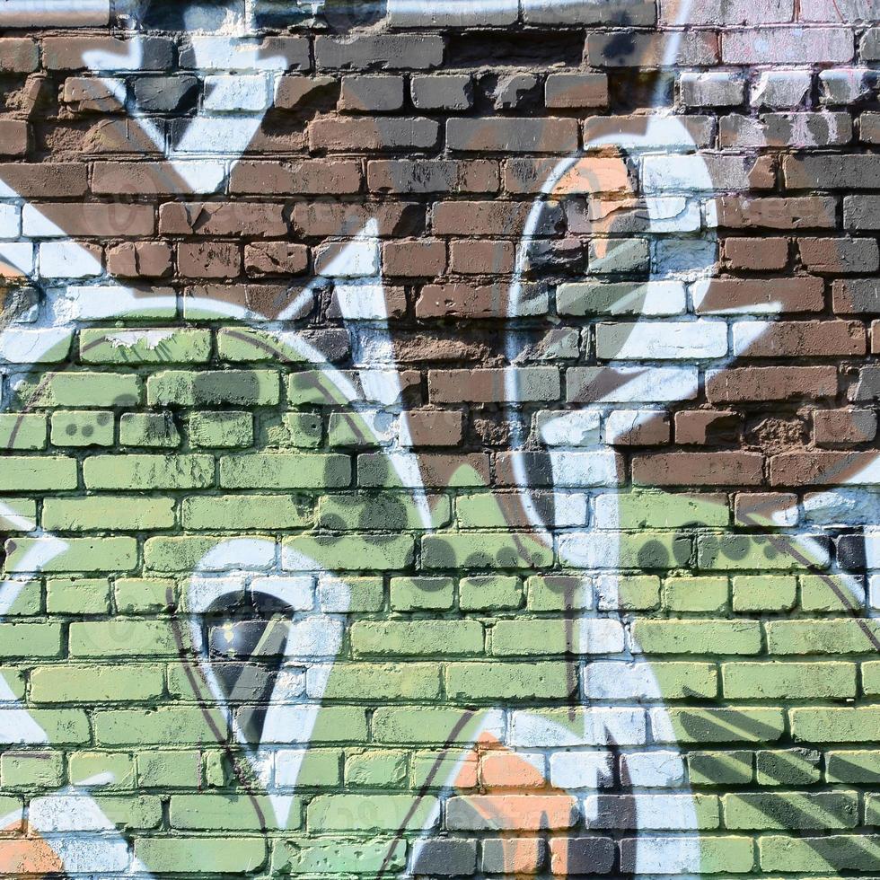 Fragment of graffiti drawings. The old wall decorated with paint stains in the style of street art culture. Colored background texture in warm tones photo