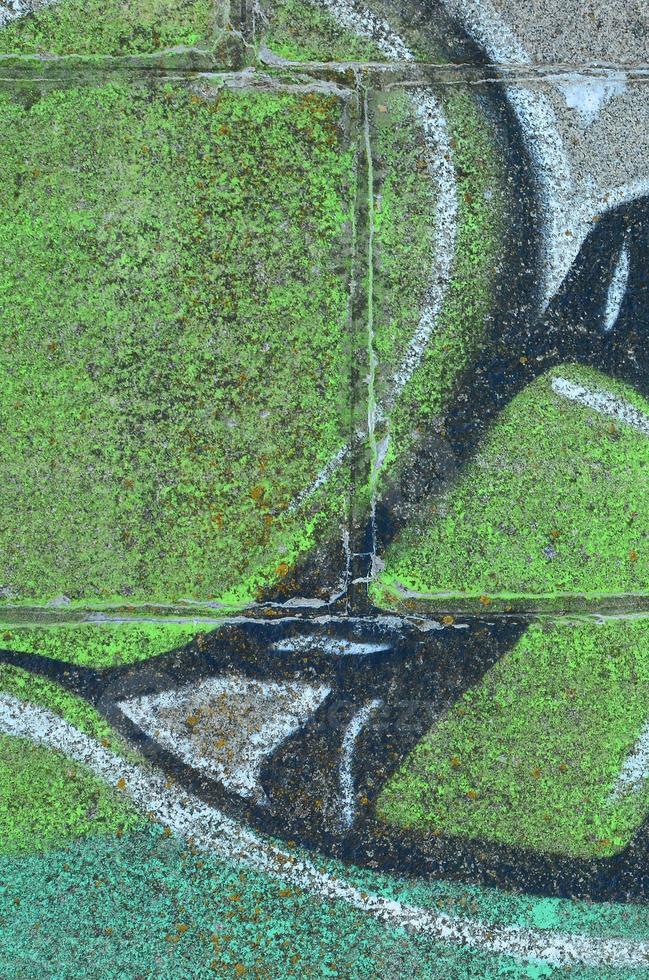 Fragment of graffiti drawings. The old wall decorated with paint stains in the style of street art culture. Colored background texture in green tones photo