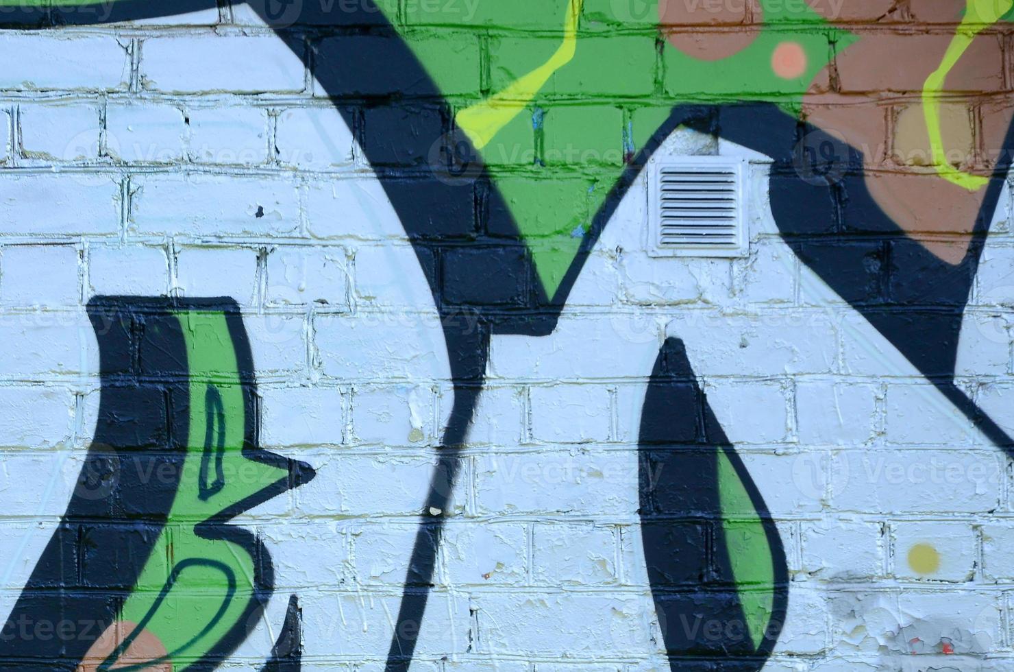 Fragment of graffiti drawings. The old wall decorated with paint stains in the style of street art culture. Colored background texture in green tones photo