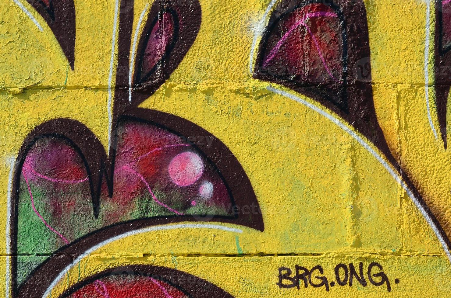 Fragment of graffiti drawings. The old wall decorated with paint stains in the style of street art culture. Colored background texture in warm tones photo