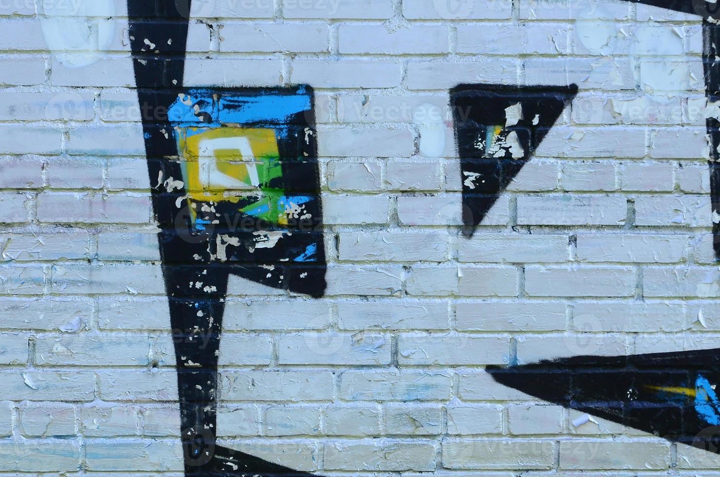 Fragment of graffiti drawings. The old wall decorated with paint stains in the style of street art culture. Colored background texture photo