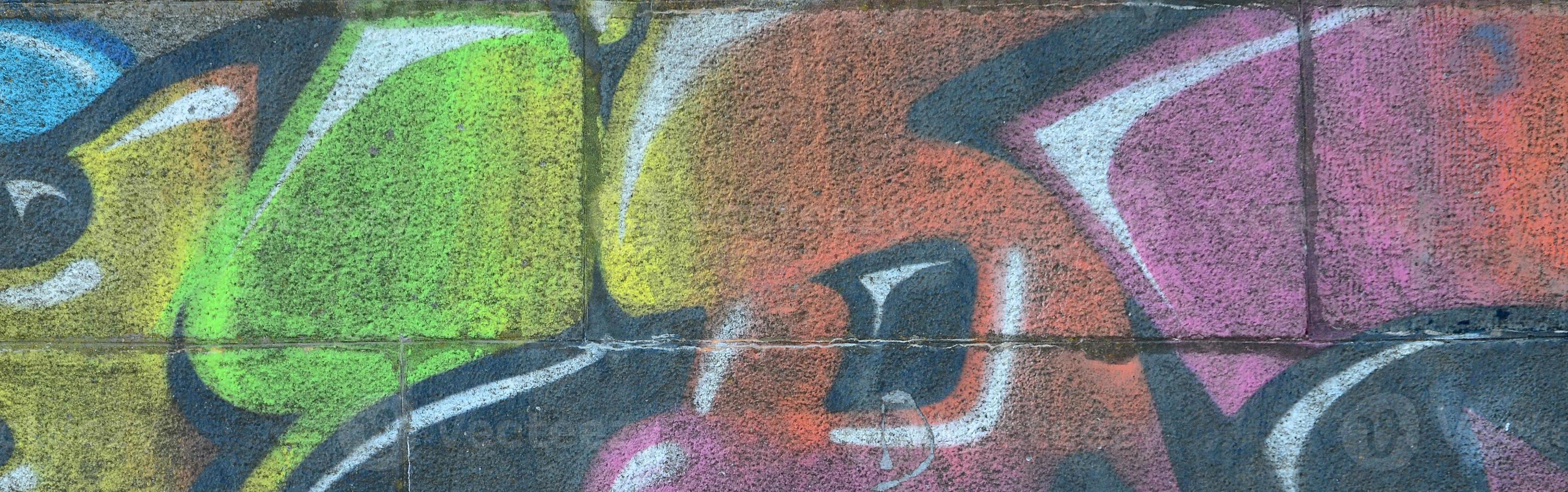 Fragment of graffiti drawings. The old wall decorated with paint stains in the style of street art culture. Multicolored background texture photo