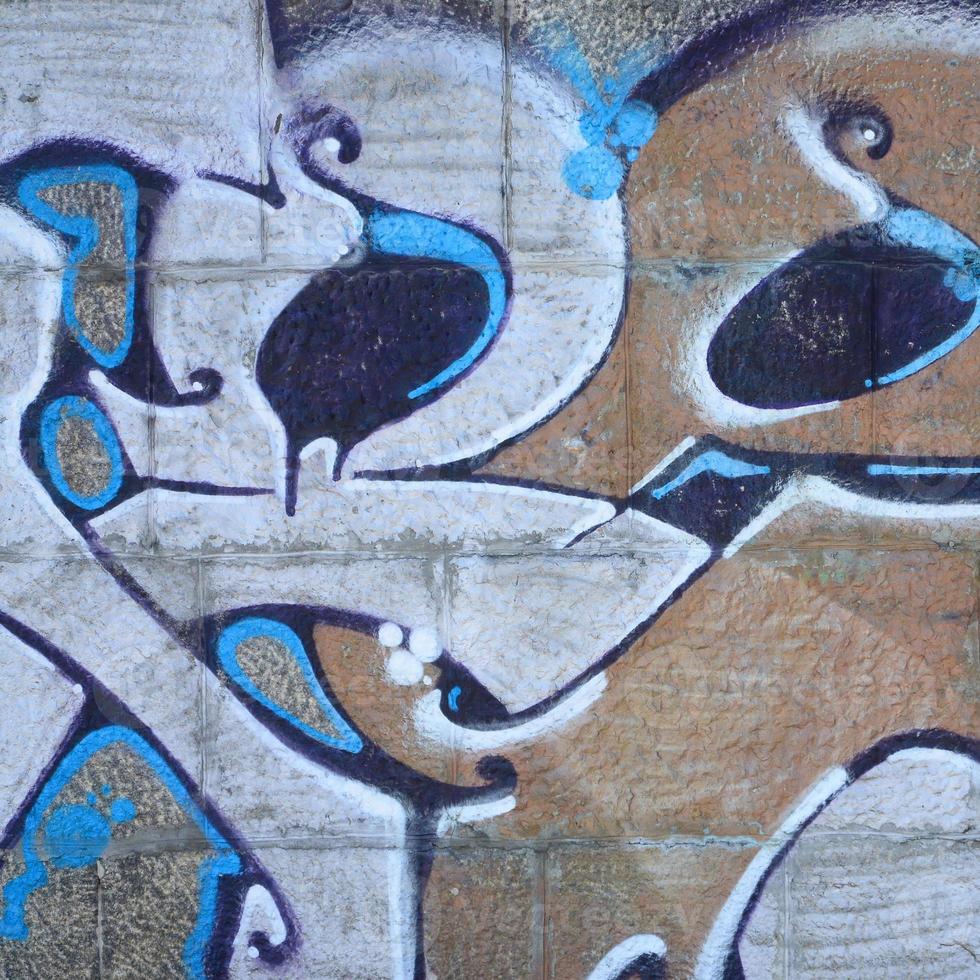 fragmento de dibujos de graffiti. la antigua muralla decorada con manchas de pintura al estilo de la cultura del arte callejero. textura de fondo coloreada en tonos cálidos foto