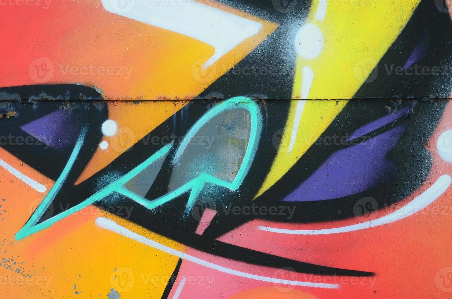 Fragment of graffiti drawings. The old wall decorated with paint stains in the style of street art culture. Colored background texture in warm tones photo