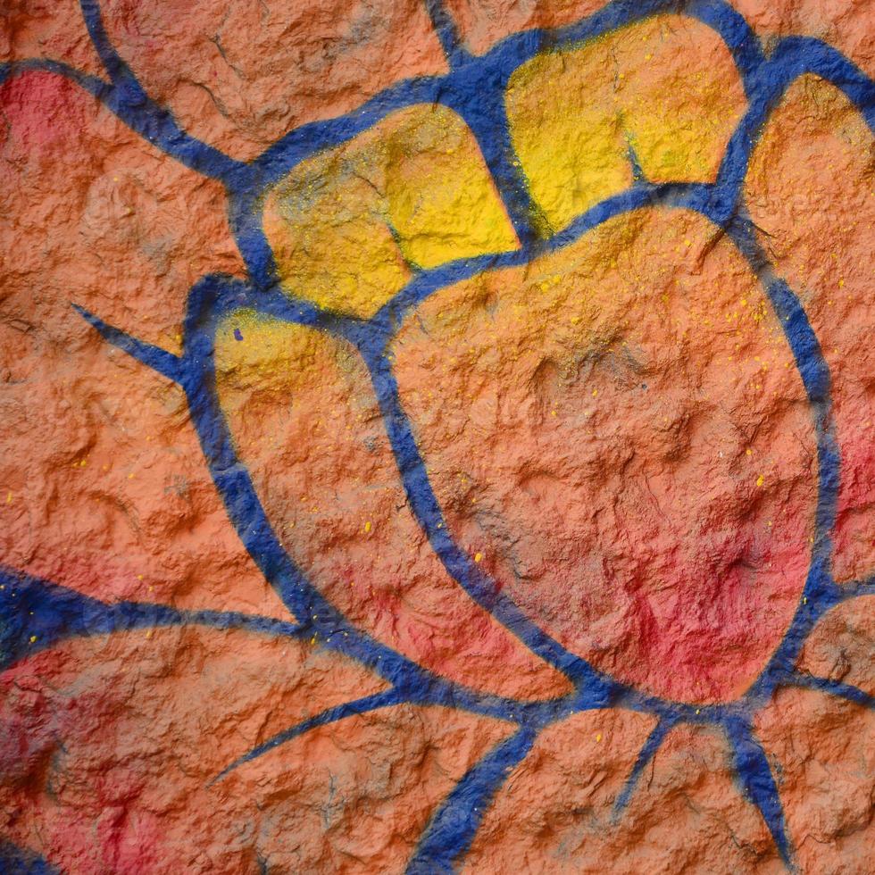 Fragment of graffiti drawings. The old wall decorated with paint stains in the style of street art culture. Orange flower photo