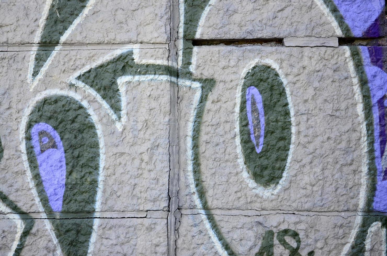 fragmento de dibujos de graffiti. la antigua muralla decorada con manchas de pintura al estilo de la cultura del arte callejero. textura de fondo coloreada en tonos morados foto