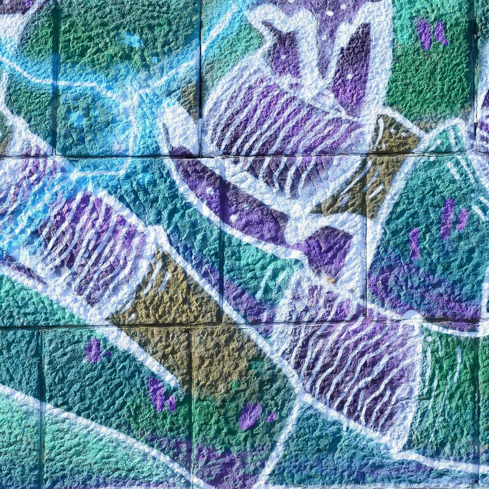 Fragment of graffiti drawings. The old wall decorated with paint stains in the style of street art culture. Colored background texture in cold tones photo