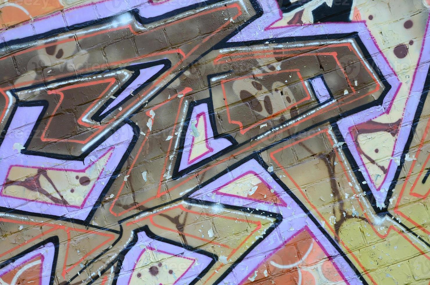 Fragment of graffiti drawings. The old wall decorated with paint stains in the style of street art culture. Colored background texture in warm tones photo