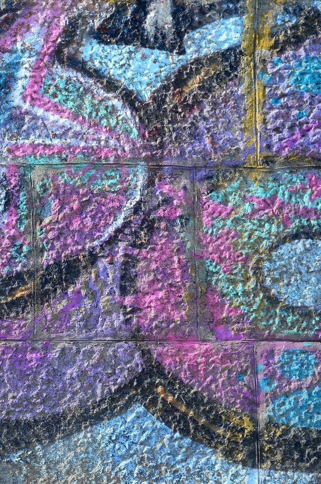 Fragment of graffiti drawings. The old wall decorated with paint stains in the style of street art culture. Colored background texture in purple tones photo