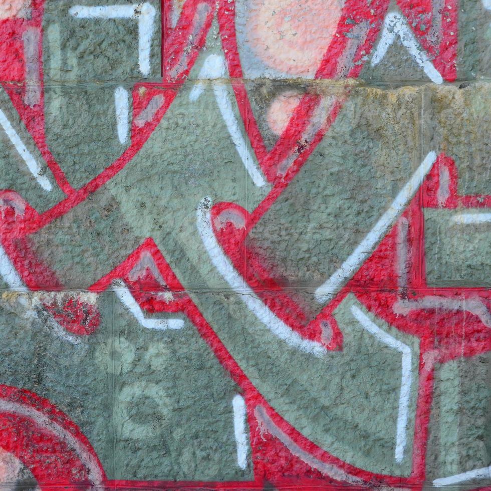 Fragment of graffiti drawings. The old wall decorated with paint stains in the style of street art culture. Colored background texture in warm tones photo