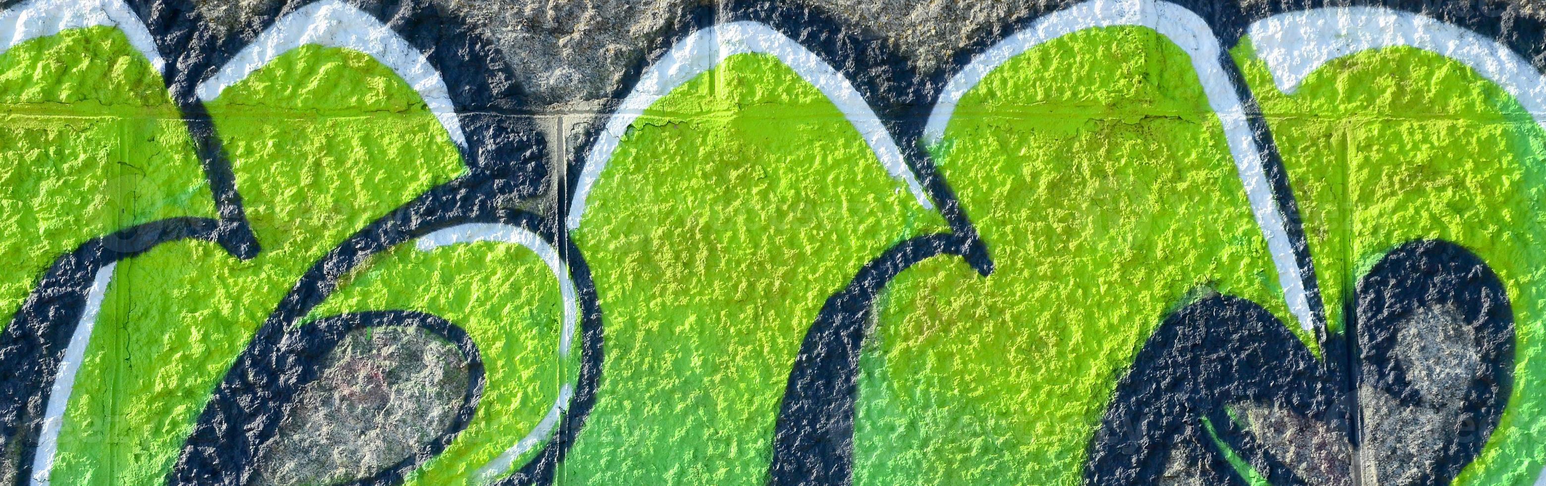 Fragment of graffiti drawings. The old wall decorated with paint stains in the style of street art culture. Colored background texture in green tones photo